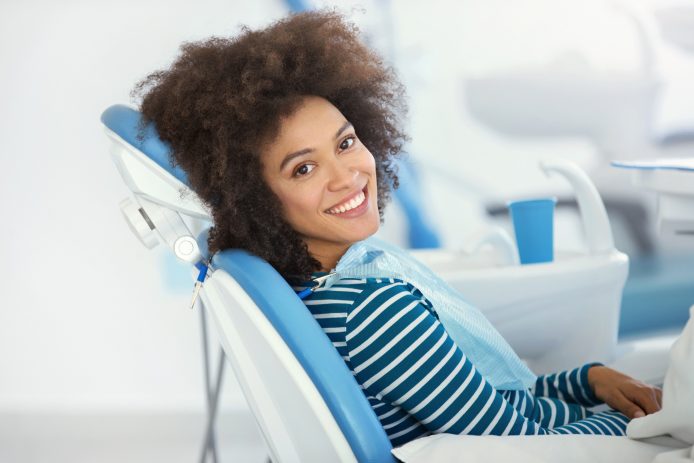 Young woman with pretty smile smiling in orthodontic chair