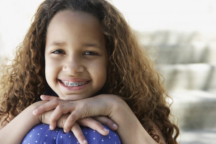 Young firl with traditional braces smiling