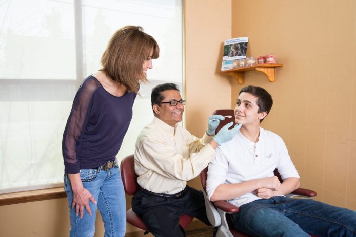 Dr. Ghosh working with teenage boy and mother