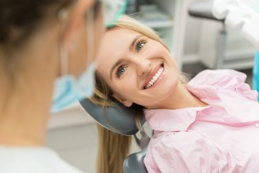 Adult woman smiling at orthodontic assistant