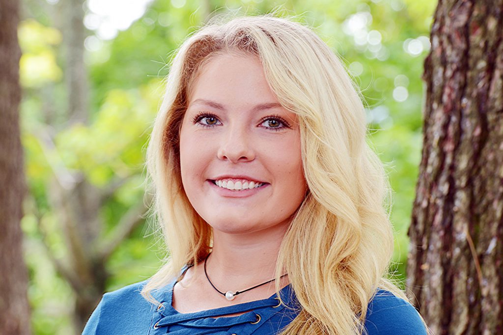 A young woman smiles after orthodontic treatment at Ghosh Orthodontics