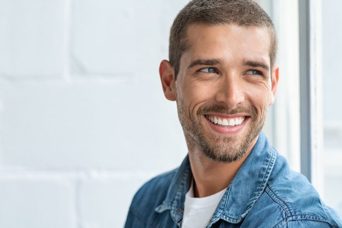 Adult male with straight, white teeth smiling.